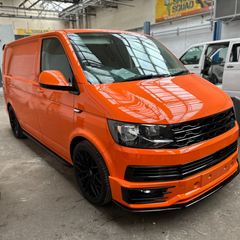 Orange van parked inside a garage with 'Spray Squad' sign in the background